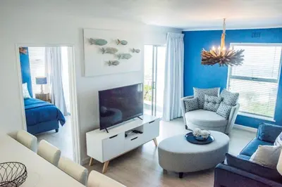 a living room with a television and blue walls at Whale Rock 40 in Hermanus