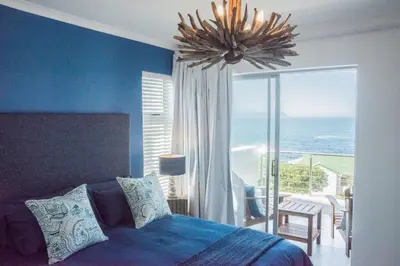 a bedroom with a bed and a view of the ocean at Whale Rock 40 in Hermanus