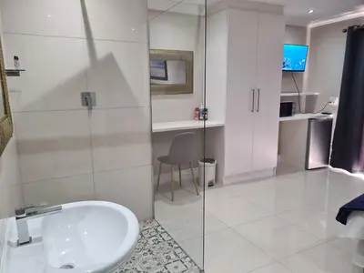 a bathroom with a sink and a glass shower at Cape Winelands Business Villas in Joostenberg Vlakte