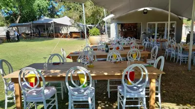 a wooden table with chairs and tables and a tent at Cape Winelands Business Villas in Joostenberg Vlakte