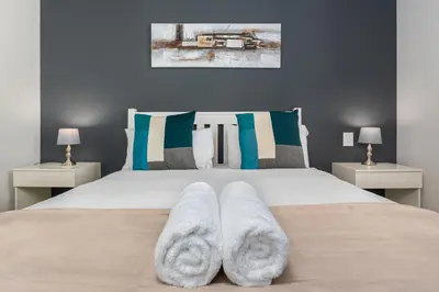 a bedroom with a large bed with two night stands at Matrix Apartments in Cape Town