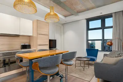 a kitchen and dining room with a table and chairs at Matrix Apartments in Cape Town