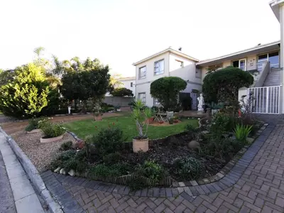 a garden in front of a house with plants at Guinea Fowl Self Catering in Cape Town