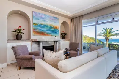 a living room with a couch and a fireplace at Hermanus Beachfront Lodge - Solar Power in Hermanus