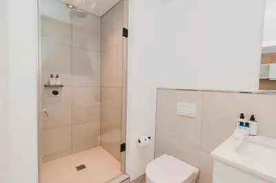 a bathroom with a shower and a toilet and a sink at Bridgewater Apartments by Century City Hotels in Cape Town