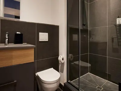 a bathroom with a toilet and a glass shower at Bridgewater Apartments by Century City Hotels in Cape Town