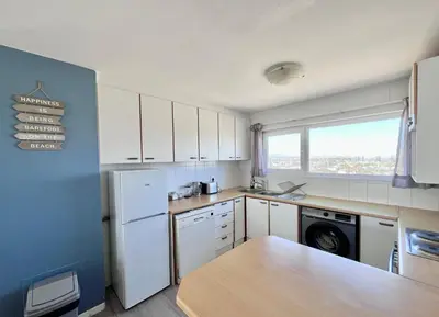 a kitchen with a white refrigerator and a window at Ocean View Apartment in Cape Town