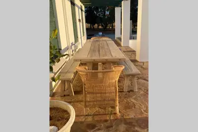 a wooden picnic table on the porch of a house at De Goede Hoop Farmstead in Wilgerhof