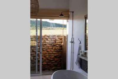 a room with a sliding glass door with a stone wall at De Goede Hoop Farmstead in Wilgerhof