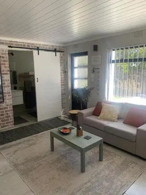 a living room with a couch and a table at Just Chill Betty's Bay in Bettyʼs Bay