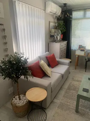 a living room with a couch and a table at Just Chill Betty's Bay in Bettyʼs Bay