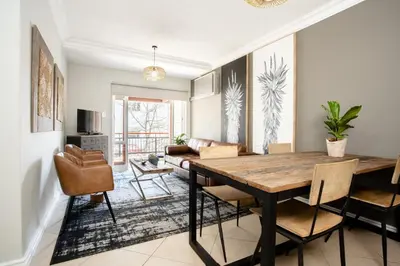 a dining room with a wooden table and chairs at Avemore Jan Cats No 3 full back up power in Stellenbosch