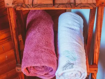 two towels sitting on a shelf in a room at Hoogeland's Wood Cabins in Eersterivier