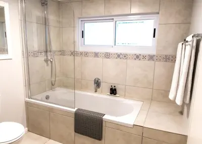 a bathroom with a bath tub and a window at Milas Place Spacious & Comfortable at Bayview in Hermanus