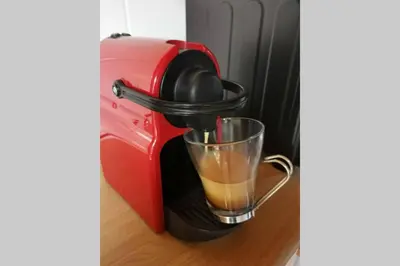 a red coffee maker with a drink in a glass at Cozy, peaceful garden cottage in Cape Town
