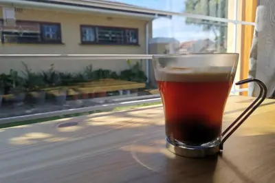a glass of beer sitting on top of a table at Cozy, peaceful garden cottage in Cape Town