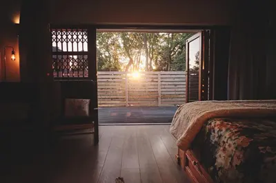 a bedroom with a bed and a door to a balcony at The Cottage Farm in Stellenbosch