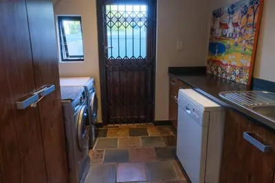 a kitchen with a refrigerator and a sink and a door at Home in Cape Town-The Homestead in Stellenbosch