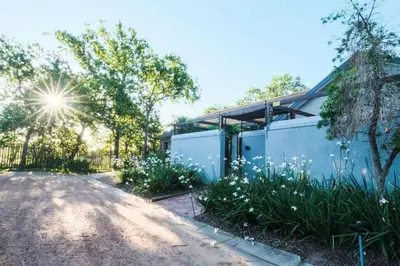 a house with a fence and some flowers at Home in Cape Town-The Homestead in Stellenbosch