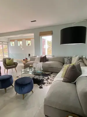 a living room with a couch and a person sitting on the floor at Beach & Mountain Retreat within a UNESCO Biosphere in Rooiels