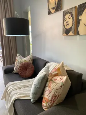 a couch with pillows on it in a living room at Beach & Mountain Retreat within a UNESCO Biosphere in Rooiels