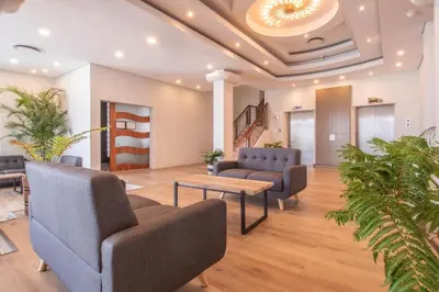 a lobby with couches and a table and plants at Tranquil Impulse on Strand in Cape Town