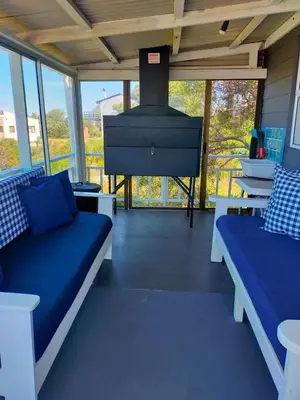 a living room with two couches and a stove at Cottage Amnesia in Bettyʼs Bay