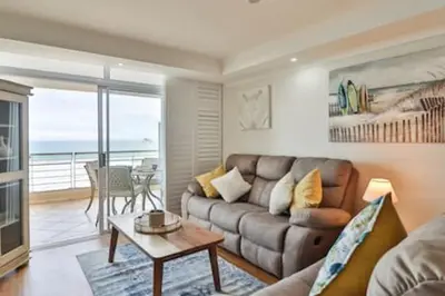 a living room with a couch and a table at Ocean View C403 by CTHA in Bloubergstrand