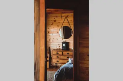 a bedroom with a bed and a dresser with a mirror at Stonewood Mountain Cabin in Breerivier