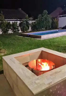 a fire pit in a concrete planter in a yard at 57 on Vermont in Hermanus