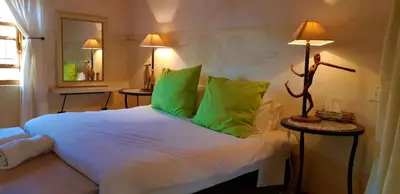 a bedroom with a large white bed with green pillows at Akkedis at Artemis in Franschhoek