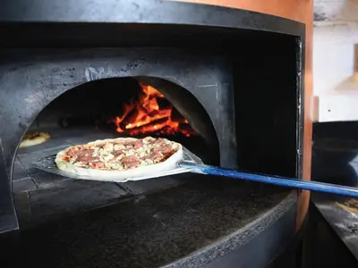 a pizza is being cooked in an oven at Century City Hotel Bridgewater in Cape Town