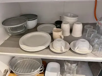 a shelf with plates and other dishes on it at Open Room Comfort in Cape Town