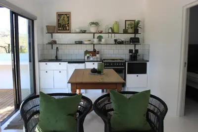 a kitchen with a wooden table and two chairs at Brenaissance Wine & Stud Estate in Stellenbosch