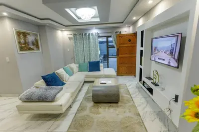 a living room with a couch and a tv at Cozier Glitz in Cape Town