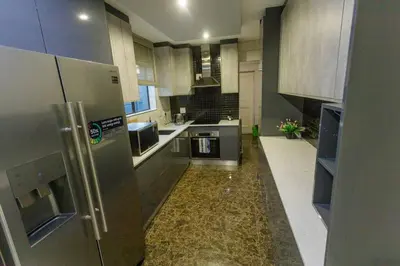a large kitchen with stainless steel appliances and marble floors at Cozier Glitz in Cape Town