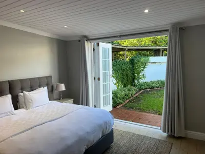 a bedroom with a bed and a sliding glass door at Sunset Farm Stellenbosch in Stellenbosch