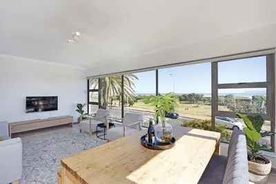 a living room with a table and a large window at Cisterama 102 in Cape Town