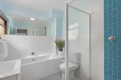 a bathroom with a toilet and a tub and a sink at Cisterama 102 in Cape Town