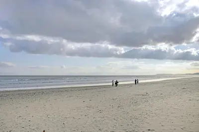a group of people walking on the beach at Cisterama 102 in Cape Town
