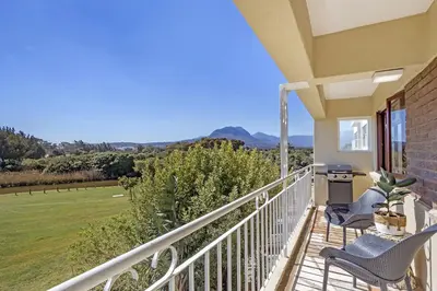 a balcony with chairs and a view of a field at Cisterama 102 in Cape Town