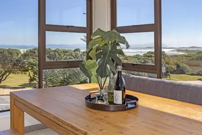 a table with a bottle of wine and a plant on it at Cisterama 102 in Cape Town