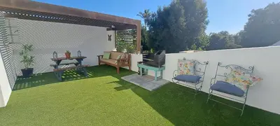 a patio with a table and chairs on the grass at Cape Dutch Flair in Durbanville
