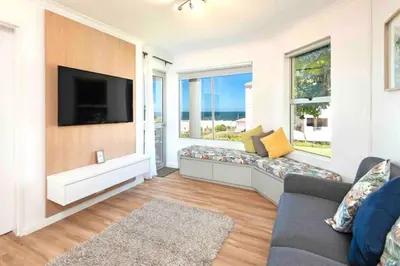 a living room with a couch and a flat screen tv at Luxury @ the Ocean in Hermanus