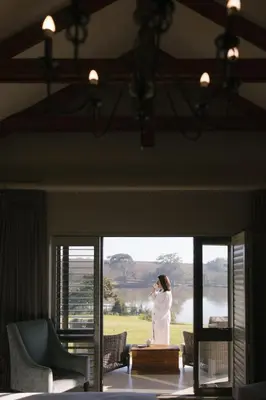a woman talking on a cell phone in a room at Under Oaks Guesthouse in Paarl