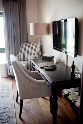 a living room with a desk with a computer and a chair at Under Oaks Guesthouse in Paarl