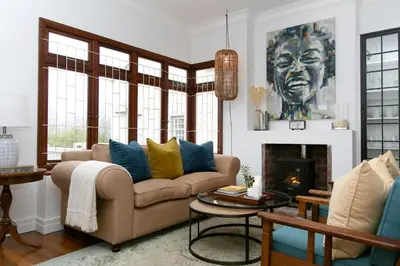 a living room with a couch and a fireplace at La Maison On Main Self-Catering Villa in Paarl