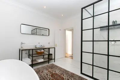 a bathroom with a sink and a mirror at La Maison On Main Self-Catering Villa in Paarl