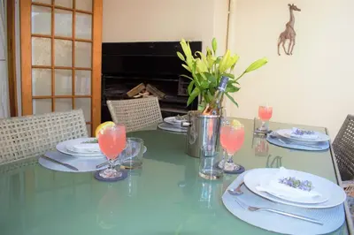 a green table with plates and glasses on it at Smith Cottage in Franschhoek