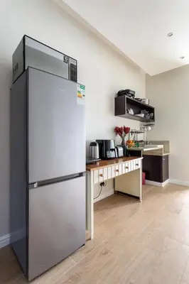 a large refrigerator in a kitchen with a table at Sunset Beach holiday accommodation in Cape Town